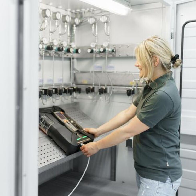 Calibración de un analizador de gases de combustión Testo por parte de un miembro del personal.