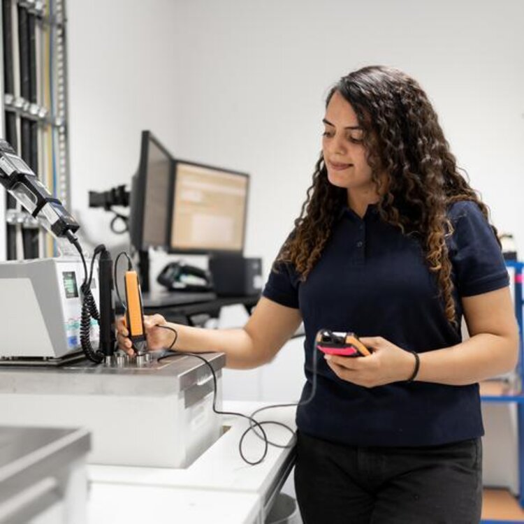 Una empleada calibra un sensor de temperatura de Testo en una cubeta de inmersión